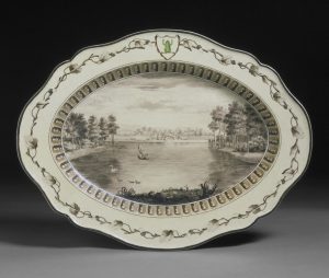 Oval, cream coloured earthenware plate from the 'Frog Service', painted with a view of the lake at West Wycombe, Buckinghamshire.